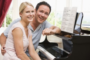 Couple sitting at piano smiling