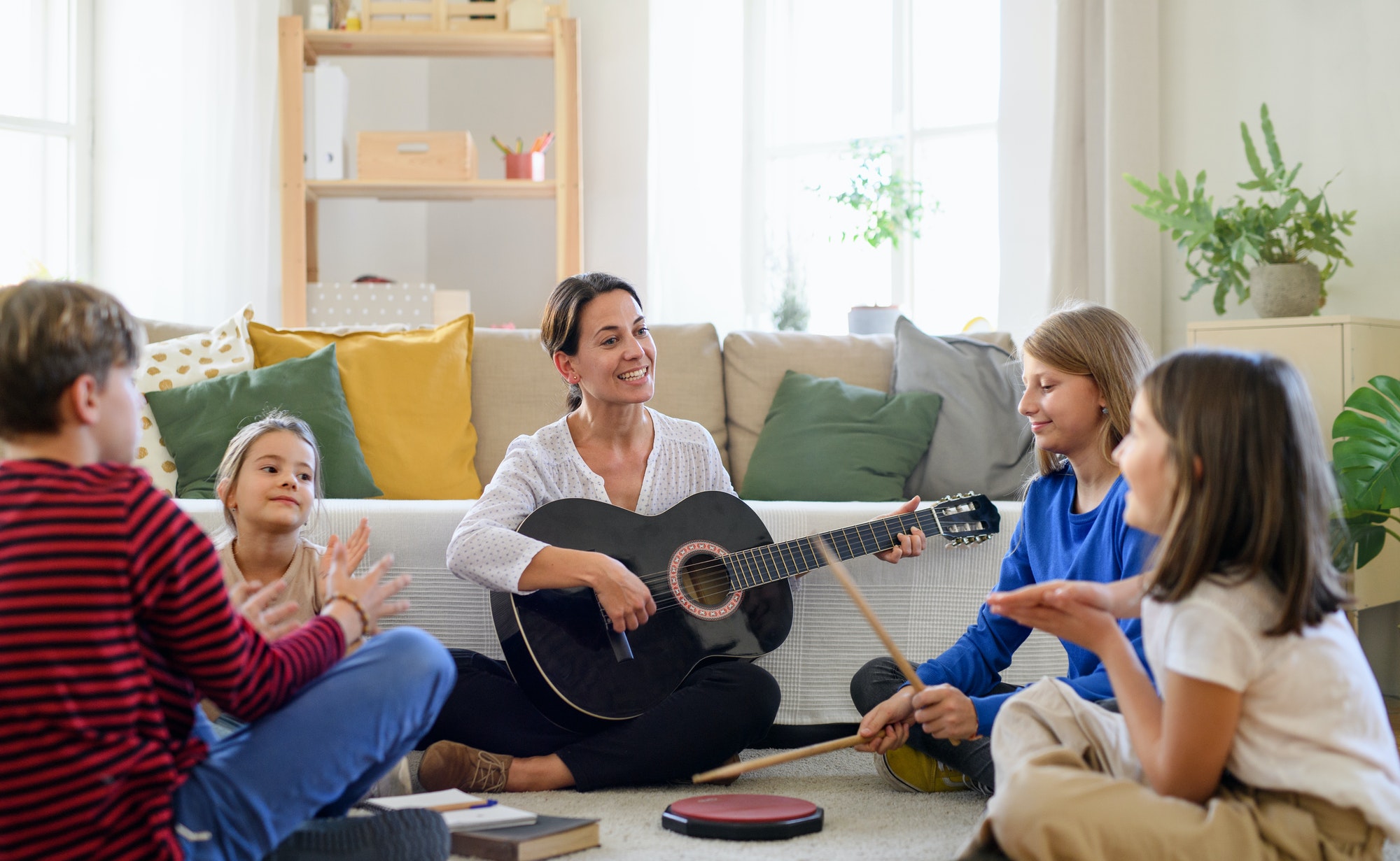 Gitarrenlehrerin mit Musikschülern